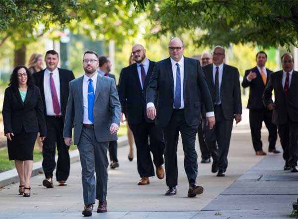 The attorneys of Spitz, the Employee's Law Firm, walking down a path in suits and ties.