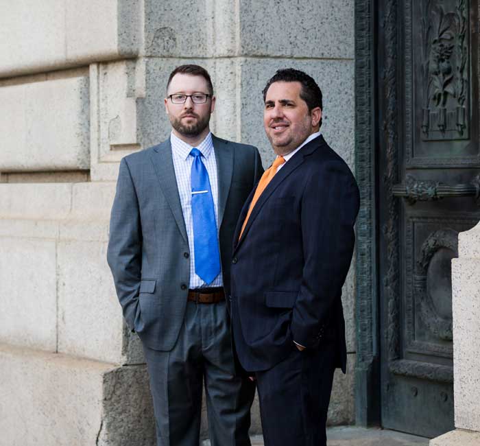 Attorney Brian Spitz and attorney Fred Bean standing near a courthouse.
