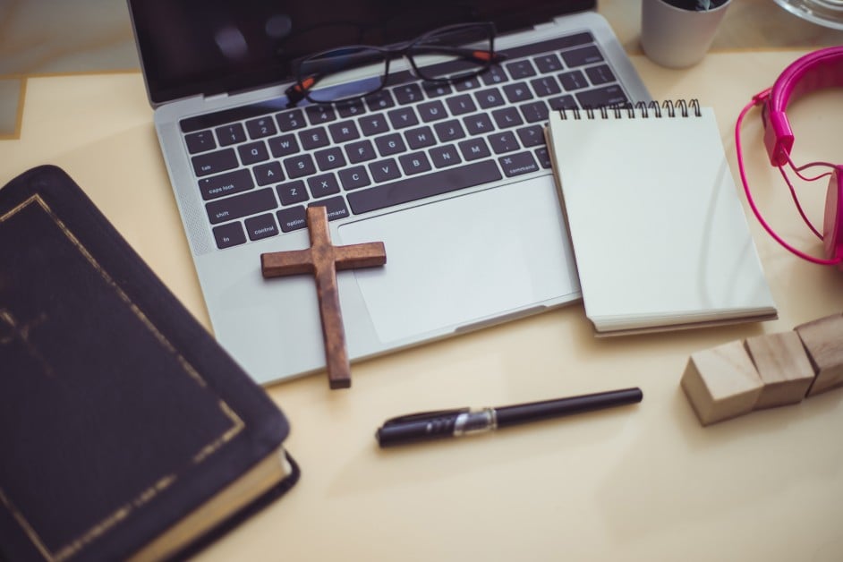 Cross necklace and employee ID badge on a desk to symbolize religious rights in the workplace.