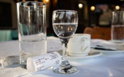 Empty restaurant table with a paycheck and tip left behind, symbolizing wage disputes in the service industry.