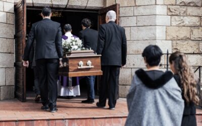 Employee receiving paperwork outside a funeral home, appearing concerned and disappointed.