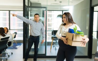 A professional worker leaving an office after being fired for reporting workplace harassment.