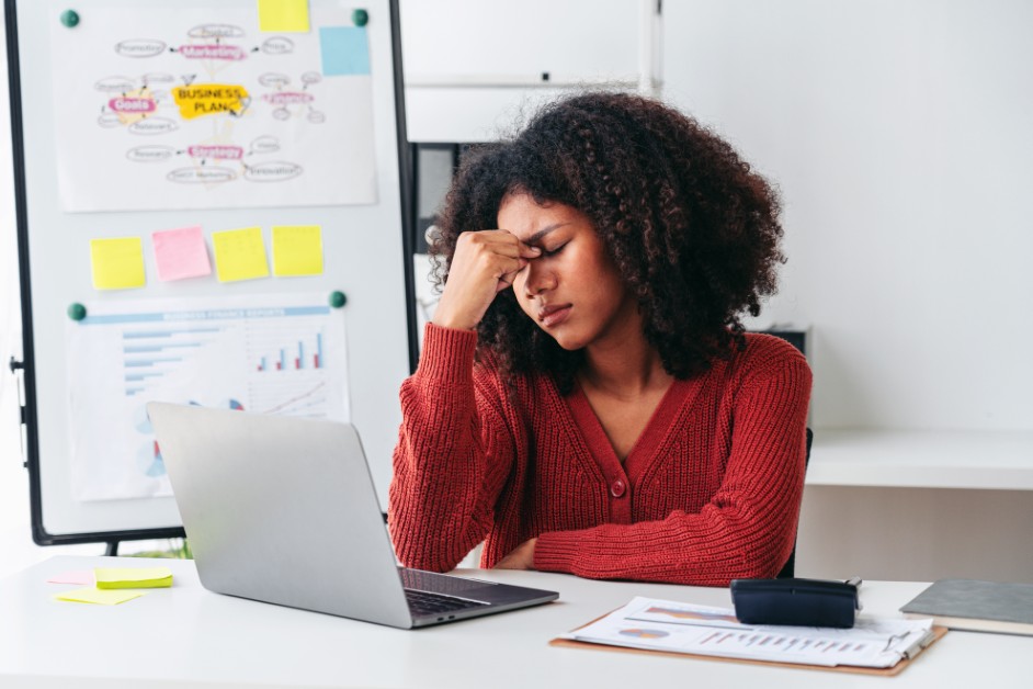 Employee sitting at a desk looking uneasy as an HR email notification appears.