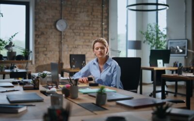 An employee sitting in an empty office holding an unfair performance review after being wrongfully fired.
