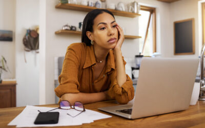 Employee sitting alone after being fired, confused and researching employment law rights.