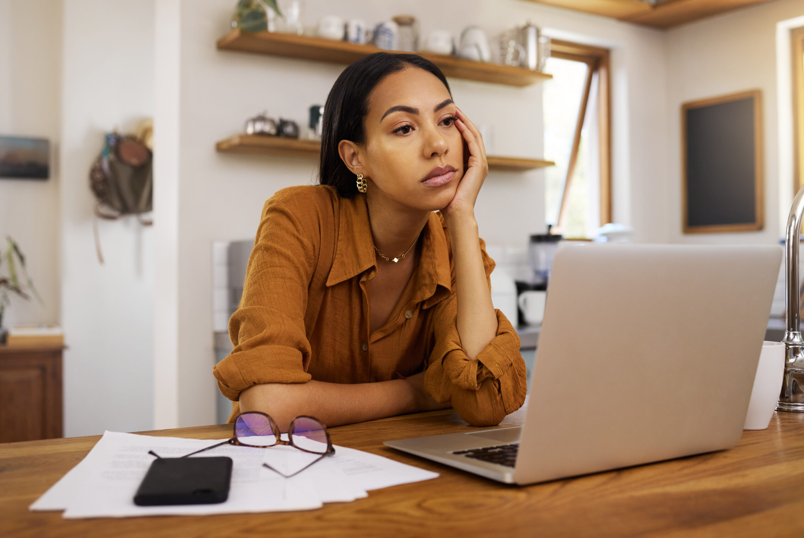 Employee sitting alone after being fired, confused and researching employment law rights.