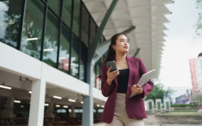 A professional woman standing outside a university building looking determined after being passed over for a leadership position.