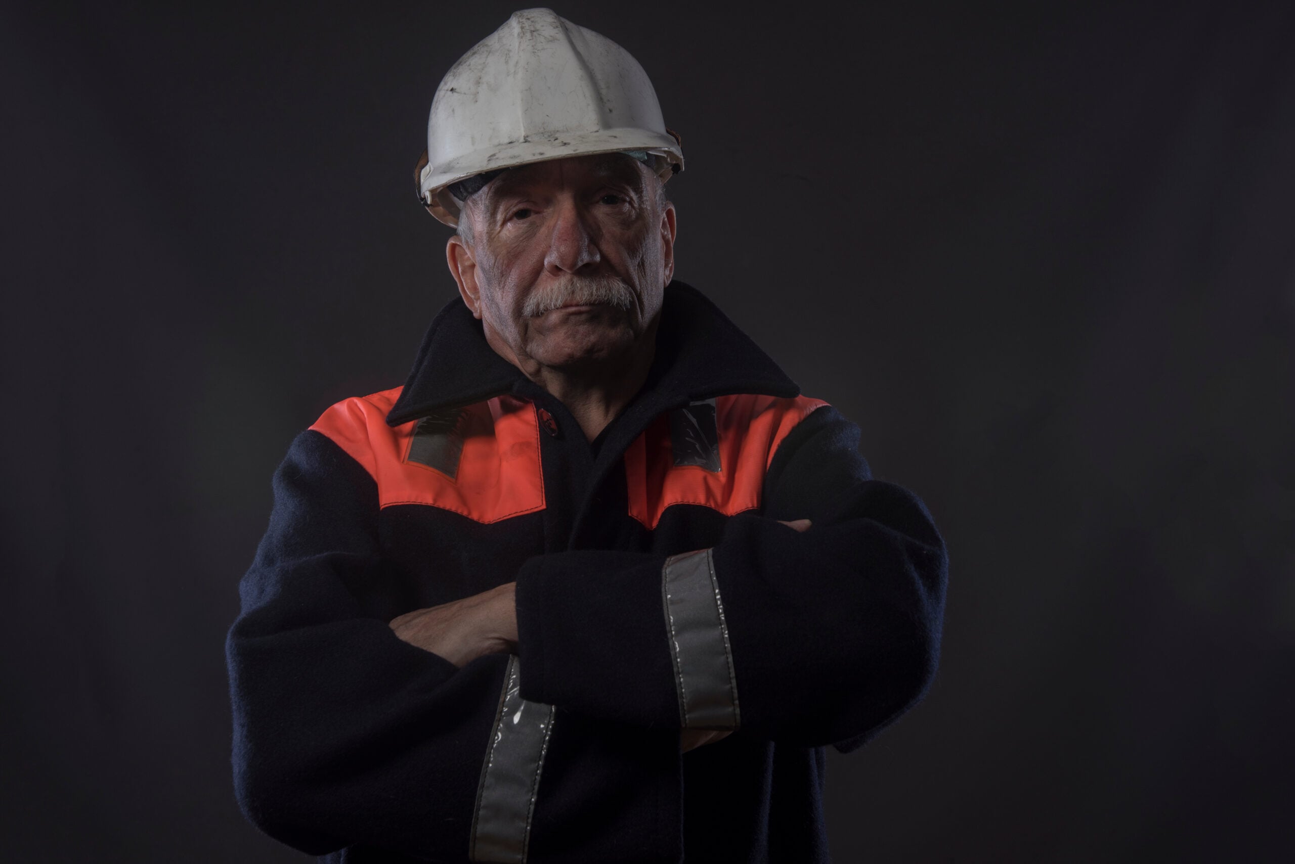 Industrial employee at underground tank site after employer denies safety equipment and disability accommodation.