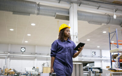 Factory supervisor walking production floor in protective gear