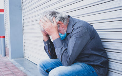 Older factory employee sitting alone after being terminated from job