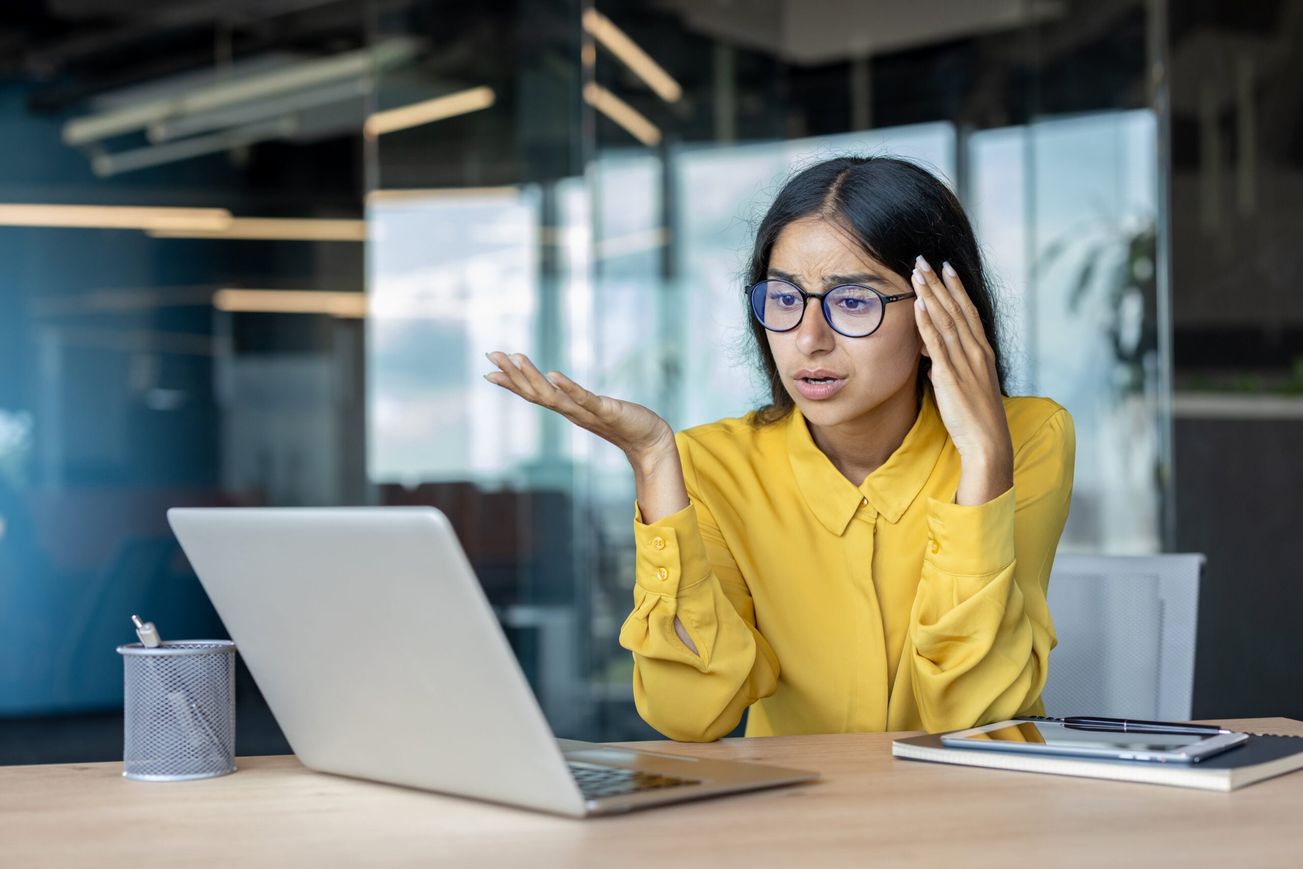 Employee sitting at desk looking frustrated after workplace conflict, representing discrimination and wrongful termination