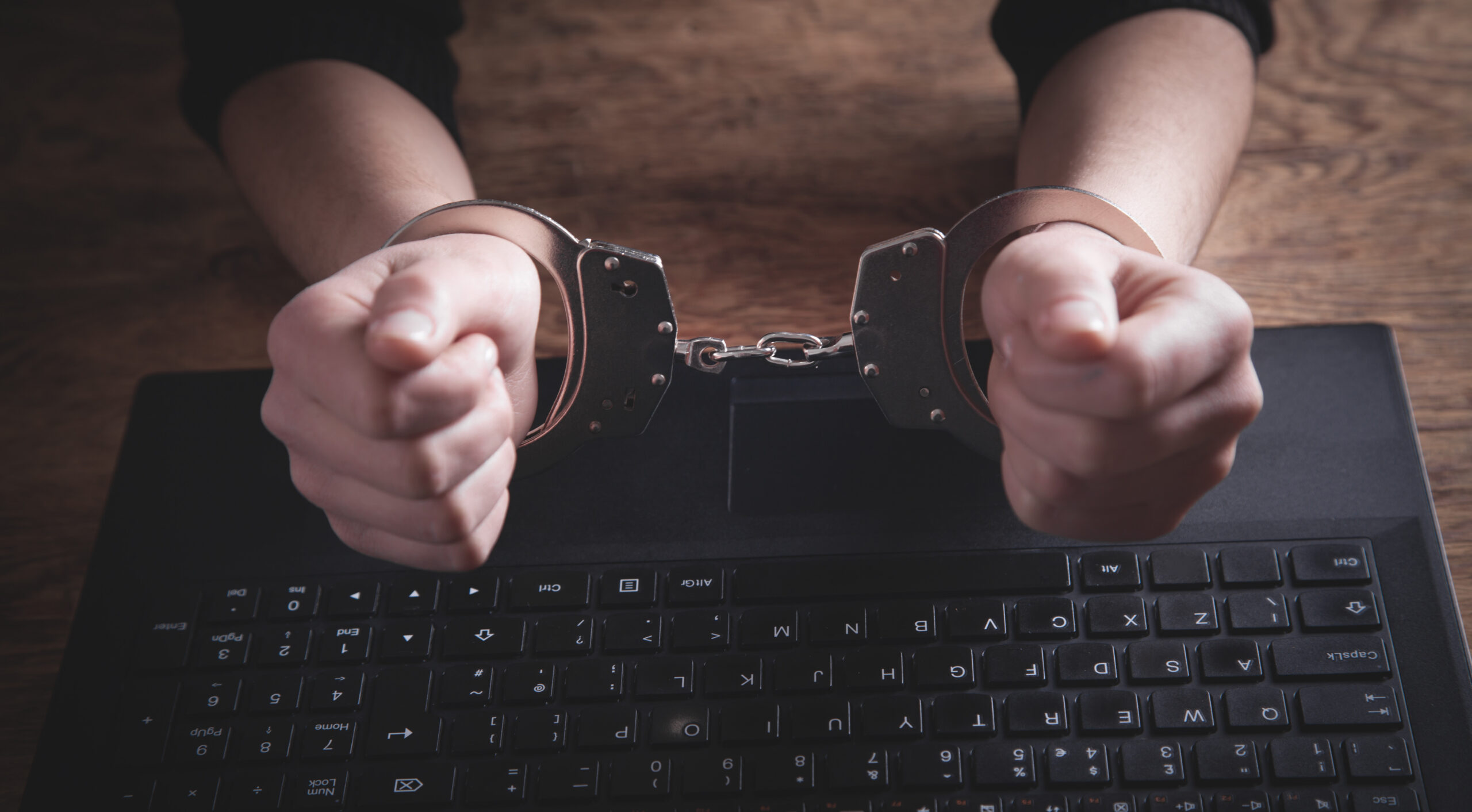 Former employee holding a company laptop outside an office building while a police vehicle waits nearby