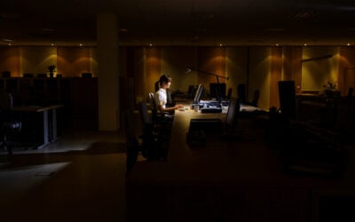 Employee sitting alone at work desk after being pressured to resign by employer