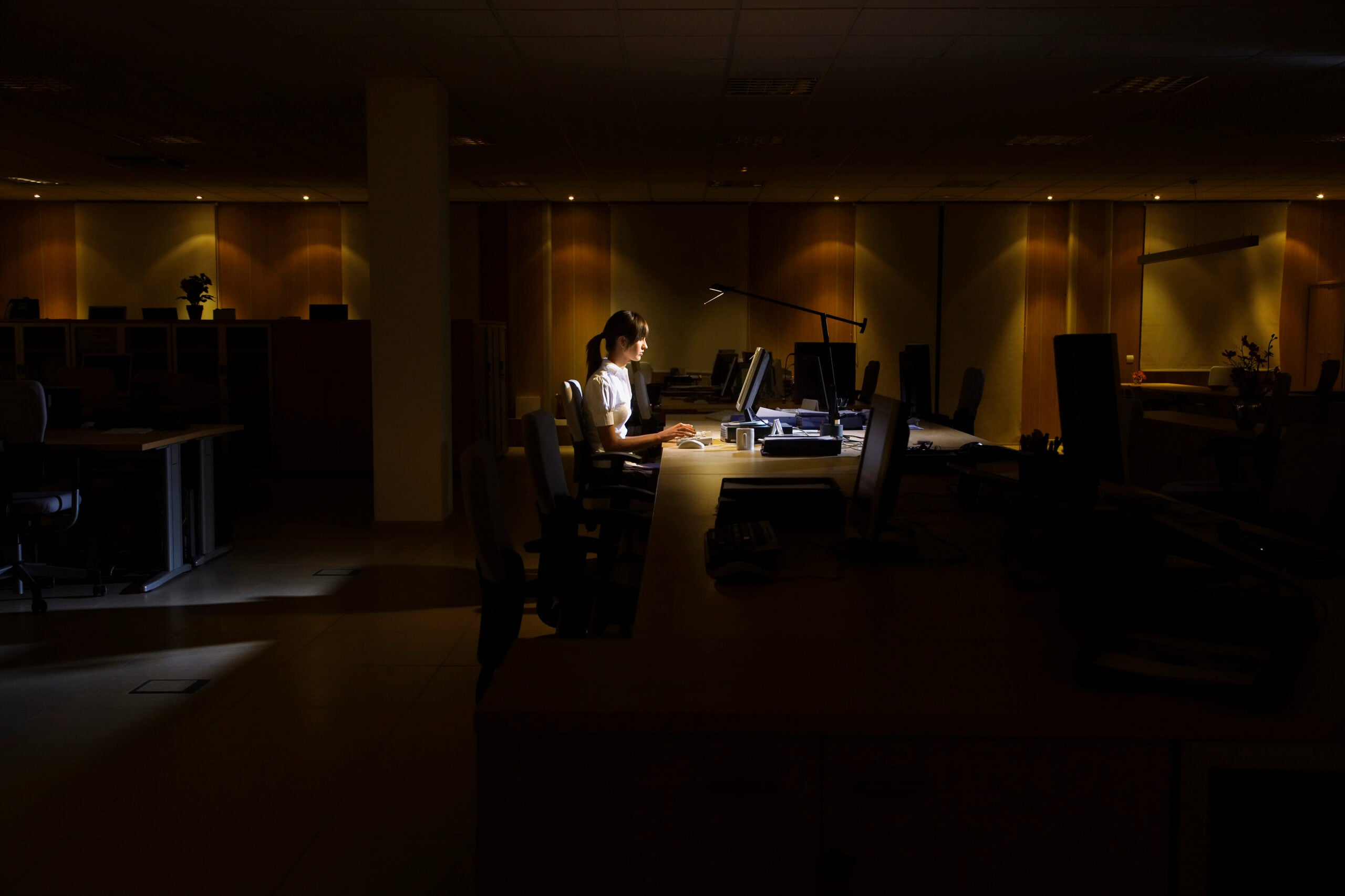 Employee sitting alone at work desk after being pressured to resign by employer