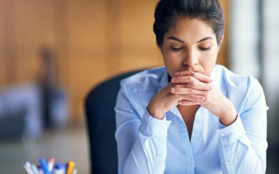 Restaurant employee standing alone in a kitchen after reporting coworker sexual harassment and hostile work environment conduct.