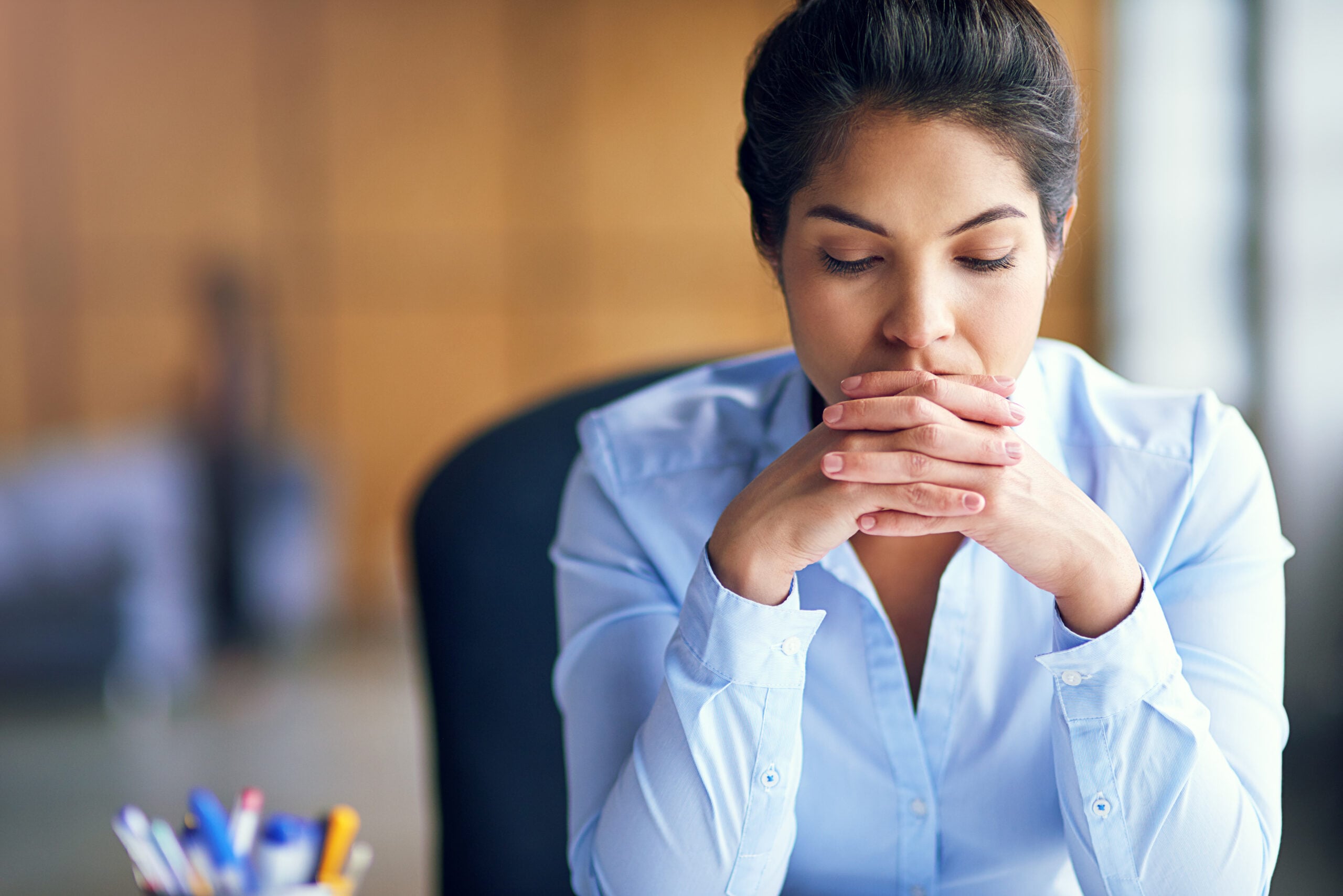 Restaurant employee standing alone in a kitchen after reporting coworker sexual harassment and hostile work environment conduct.