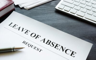 Employee reviewing unpaid medical leave, FMLA paperwork, ADA accommodation forms, and household bills at a kitchen table