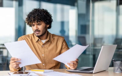 Confused employee reviewing FMLA paperwork, medical leave forms, and employment law documents after workplace stress.