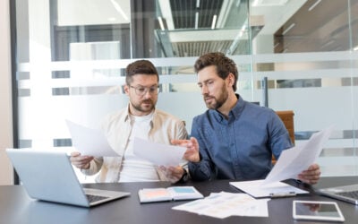 Two employees studying court papers together before handling their own employment discrimination appeal without an employment lawyer.
