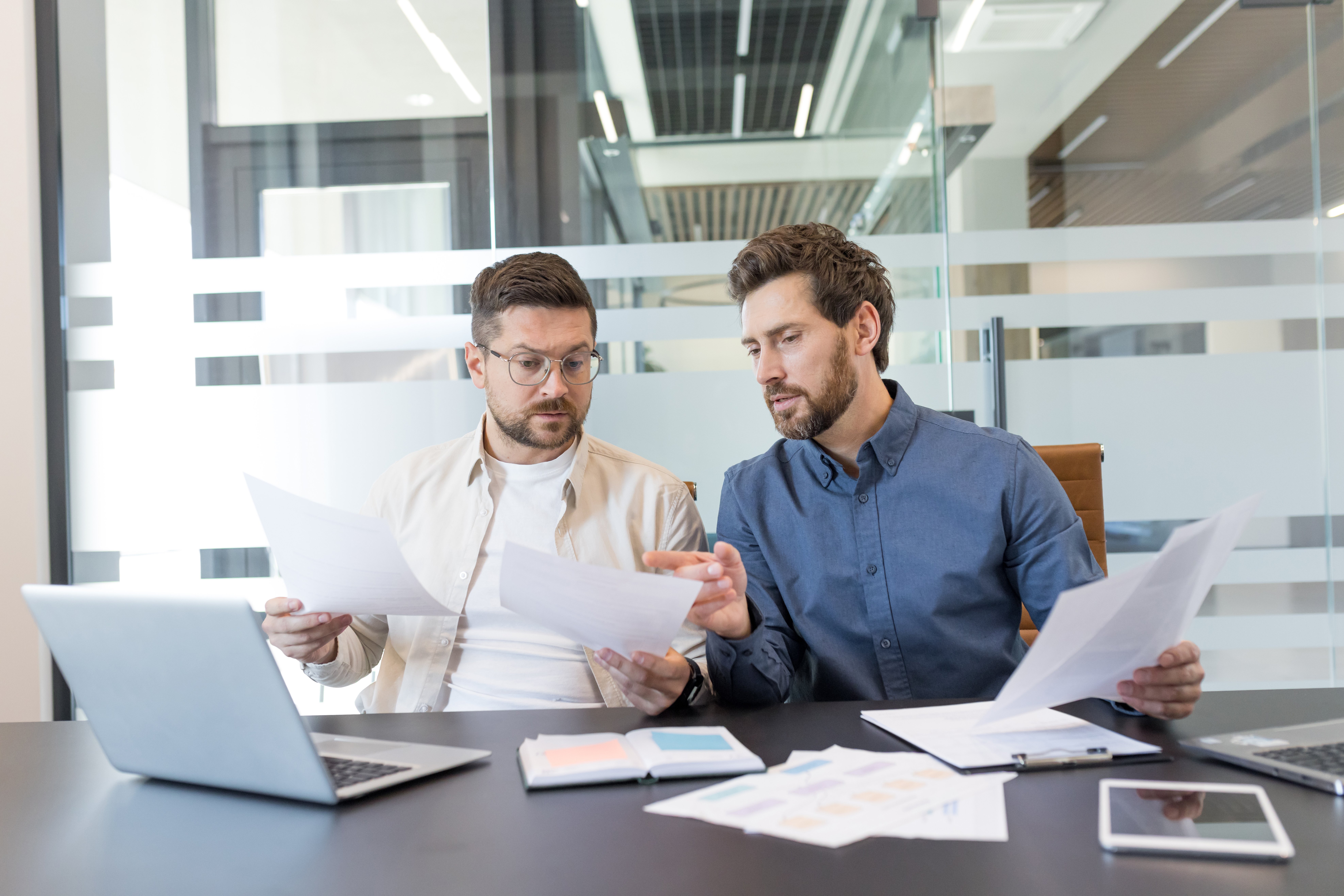 Two employees studying court papers together before handling their own employment discrimination appeal without an employment lawyer.