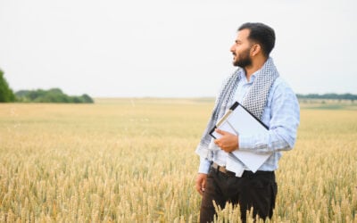 H-2A migrant farm employee working in a field while facing workplace coercion, visa threats, and deportation threats