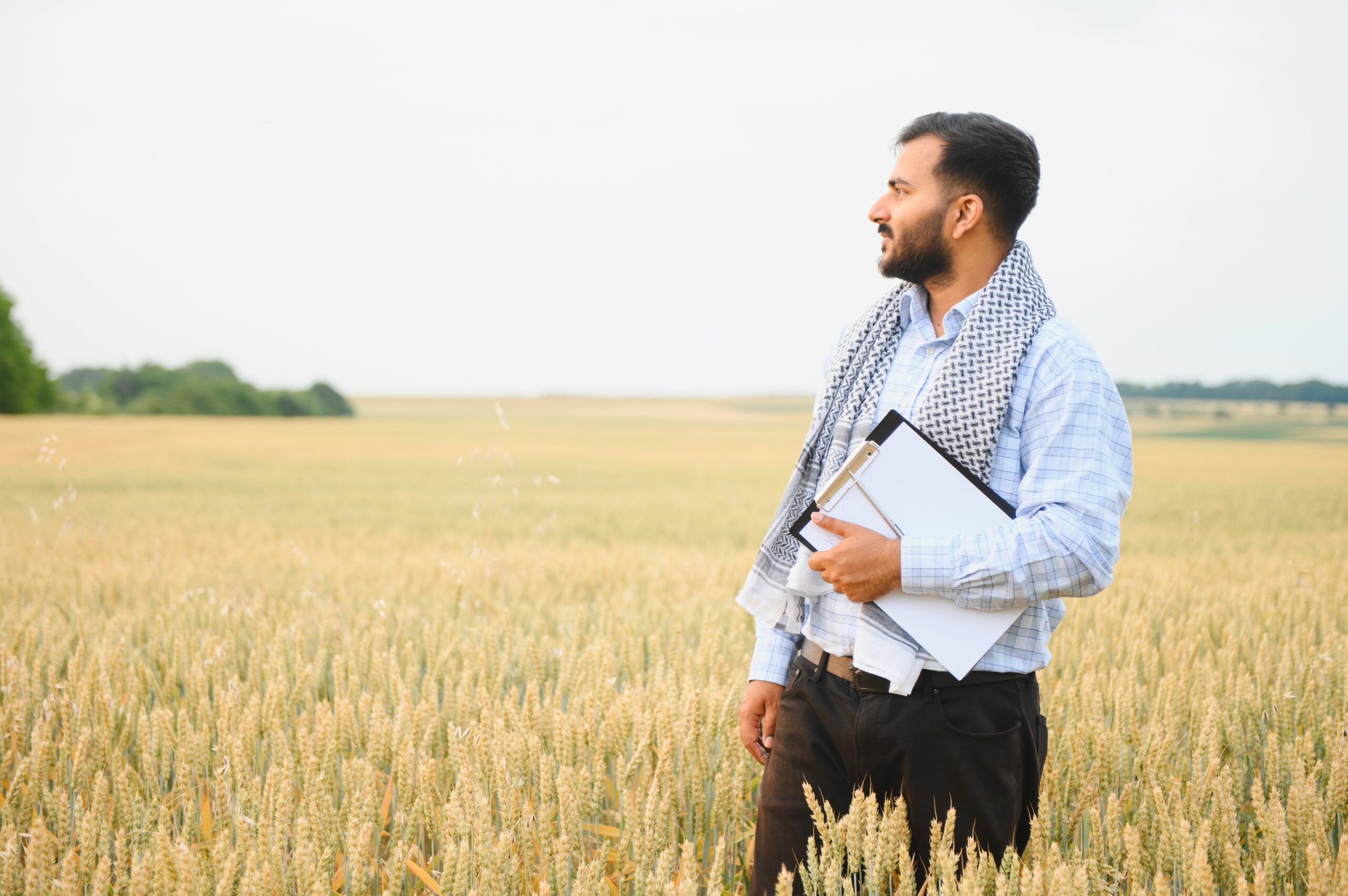 H-2A migrant farm employee working in a field while facing workplace coercion, visa threats, and deportation threats