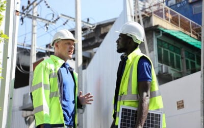 Black and white construction employees working together at an industrial jobsite.