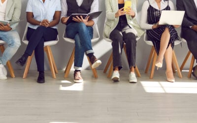 Diverse group of job candidates waiting outside an interview room during a hiring process.